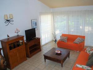 ein Wohnzimmer mit einem orangenen Sofa und einem TV in der Unterkunft Casa Bellissima in Calafat