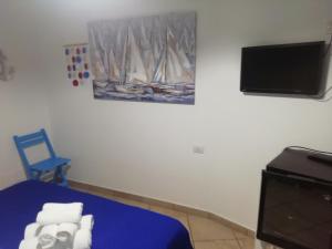 a room with a bed and a tv and towels at B&B Acquamarina Villasimius in Villasimius