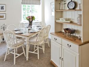 a dining room with a table and chairs at Tennay Cottage in Wareham