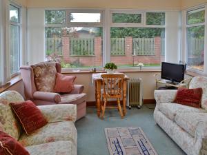 a living room with two couches and a television at South Cleeve Bungalow in Otterford