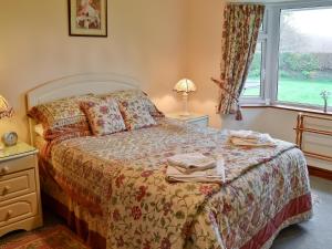 a bedroom with a bed and a window at South Cleeve Bungalow in Otterford