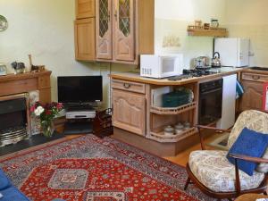 a living room with a kitchen with a stove top oven at The Stable in Crundale