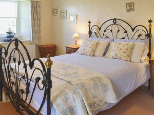 a bedroom with a large bed with a black frame at Birkerthwaite Farmhouse in Eskdale