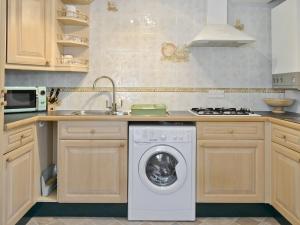 a kitchen with a washing machine and a sink at Tennay Cottage in Wareham