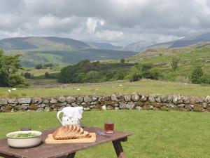 a table with a tea kettle and bread on it at Birkerthwaite Farmhouse in Eskdale