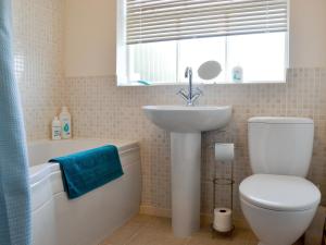 a bathroom with a toilet and a sink and a tub at Hanson Avenue in Honington