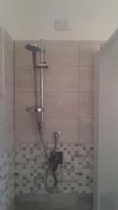 y baño con ducha y cabezal de ducha. en Casa del Geco en Rinella