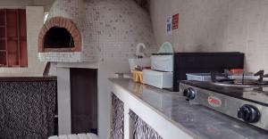 a kitchen with a stove and a brick oven at Unique Owl Apartments in Sanyang