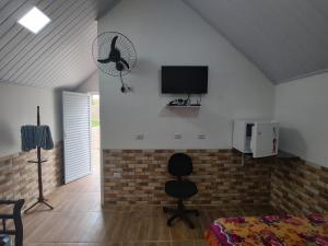 a bedroom with a bed and a fan on the wall at Chalé Arizona in São Roque