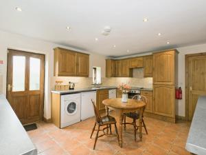 a kitchen with a table and a washing machine at Dipper Fold in Hebden