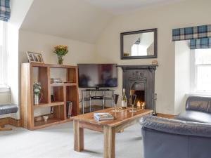 a living room with a coffee table and a fireplace at Sandhaven in Culross