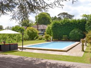 a swimming pool in a yard with an umbrella at The Sanctuary in Little Chart