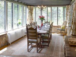 a dining room with a table and chairs and windows at The Sanctuary in Little Chart