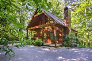 una cabaña de madera en el bosque con árboles en Rustic Smoky Mountain Cabin with Hot Tub and Fireplace en Sevierville