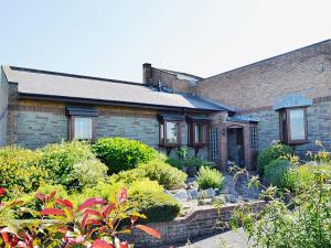 een bakstenen huis met een tuin ervoor bij Maes Y Wawr in Trostre