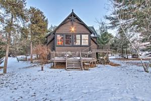 a log cabin with a deck in the snow at Waterfront Arkdale Retreat 2 Acres with Deck and View in Arkdale