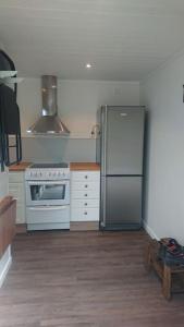 a kitchen with a refrigerator and a stove at Nyrenoverad charmig gäststuga med sovloft i Järpen in Järpen