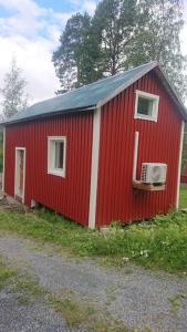 a red building with a air conditioner on it at Nyrenoverad charmig gäststuga med sovloft i Järpen in Järpen