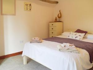 a bedroom with two beds and a dresser at Thyme - E4485 in Ludham