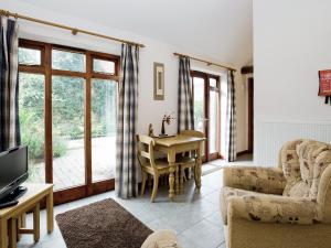 a living room with a table and chairs and a television at Thyme - E4485 in Ludham