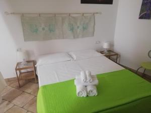 een slaapkamer met een bed en 2 rollen handdoeken bij B&B Acquamarina Villasimius in Villasimius