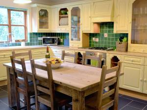 a kitchen with a table with a bowl of fruit on it at Birchwood in Marhamchurch