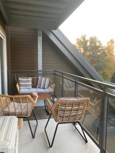 2 sillas y una mesa en el balcón en Le Haven in MSA en Beaupré