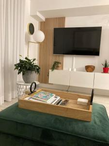 a living room with a coffee table and a tv at Le Haven in MSA in Beaupré