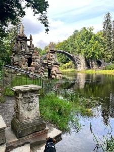 ピルナにあるDas Ferienhaus mit Aussichtの橋付き川の横の石像