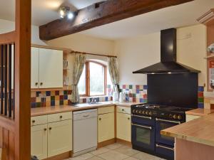 a kitchen with a stove and a sink at The Stables in Somersal Herbert