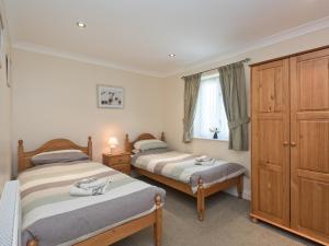 a bedroom with two beds and a window at Puddle Inn Duck in Horning