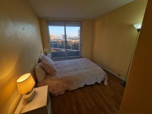 a small bedroom with a bed and a window at chambre privée in Puteaux