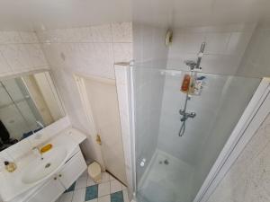 a white bathroom with a shower and a sink at chambre privée in Puteaux