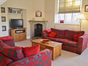 a living room with two couches and a tv at The Old School House in Tideswell