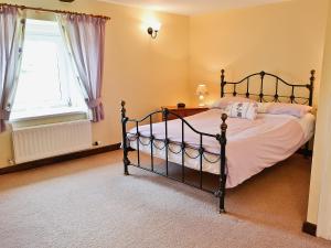 a bedroom with a bed and a window at Holmlea in Beckfoot