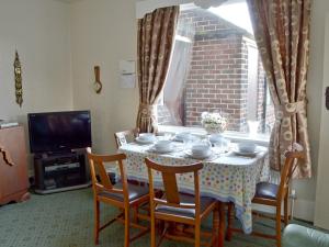 ein Esszimmer mit einem Tisch, Stühlen und einem TV in der Unterkunft Marstan House in Standish
