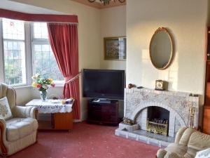 a living room with a fireplace and a television at Marstan House in Standish