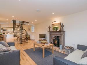 uma sala de estar com uma lareira e uma mesa em Hall Cottage em Brampton