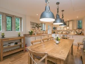 uma cozinha com uma mesa de madeira e cadeiras em Hall Cottage em Brampton