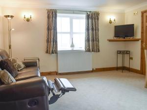 a living room with a couch and a television at No 2 Pegraig Draw - Uk6435 in Llanychaiarn