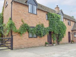 a brick house with ivy on the side of it at Mill Cottage in Mathon