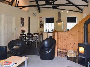 a living room with a stove and a kitchen at The Old Pumphouse in Thropton