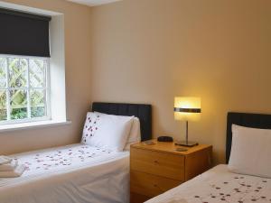 1 dormitorio con 2 camas y ventana en The Old Pumphouse, en Thropton