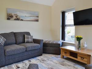 a living room with a couch and a tv at Roath in Cilcennin