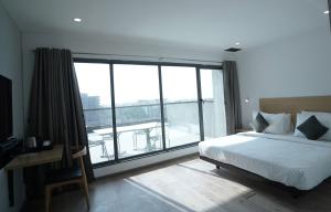 a bedroom with a bed and a large window at Terrazzo Suits in Ahmedabad