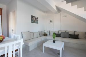 a white living room with a couch and a table at Villa Endless Blue in Kalamitsi