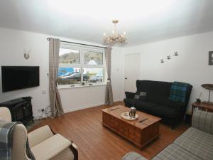 a living room with a couch and a table at Mackenzie Cottage in Poolewe