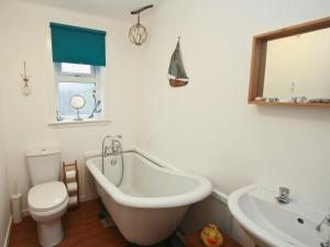 a bathroom with a tub and a toilet and a sink at Mackenzie Cottage in Poolewe