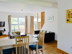 a dining room and living room with a table and chairs at Torsa - 28790 in Clachan