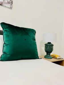 a green pillow sitting on top of a bed with a table at Tugela Mouth, Beach views in Tugela Mouth